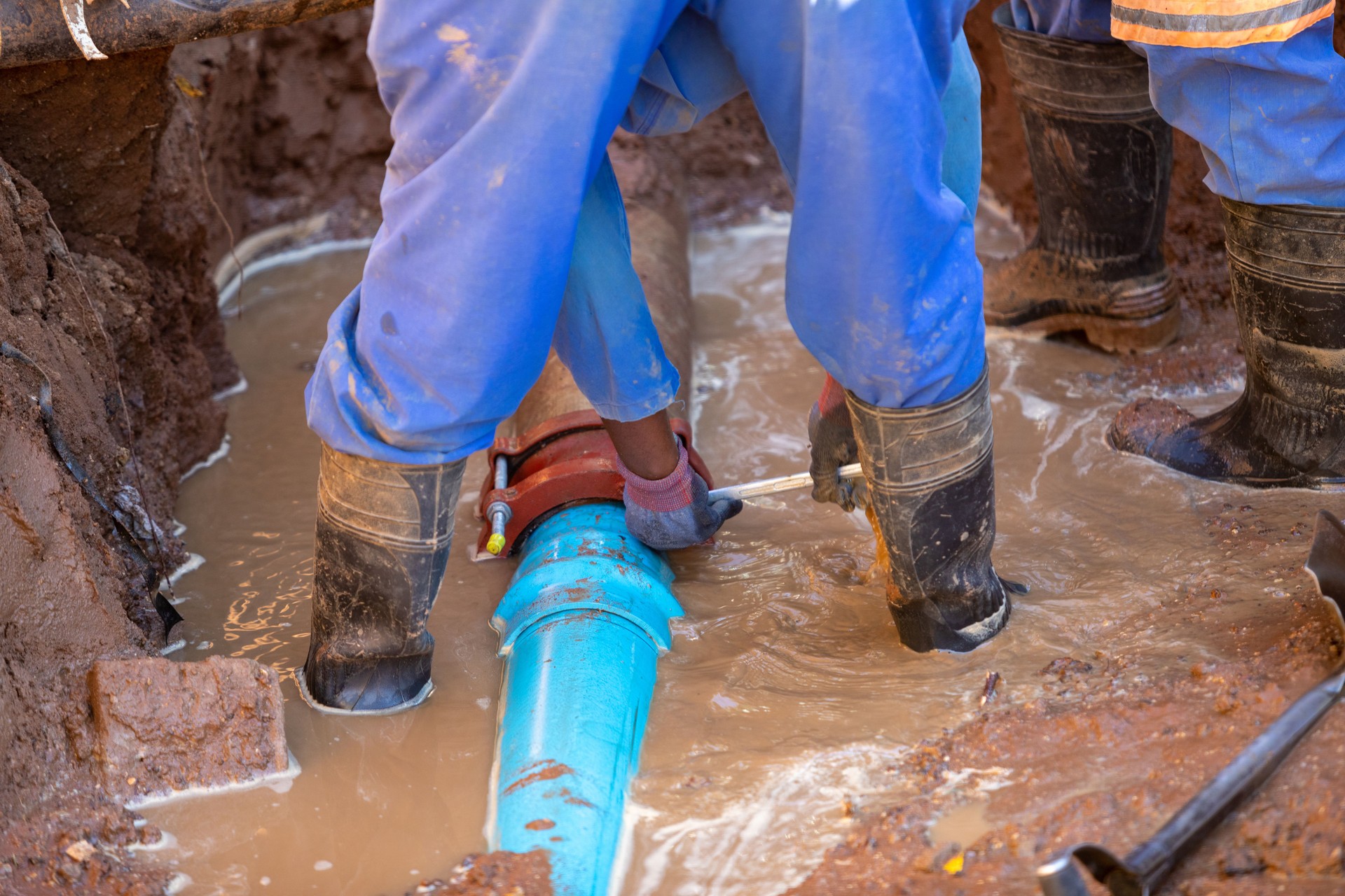 African repairman attending to the city water supply repairs